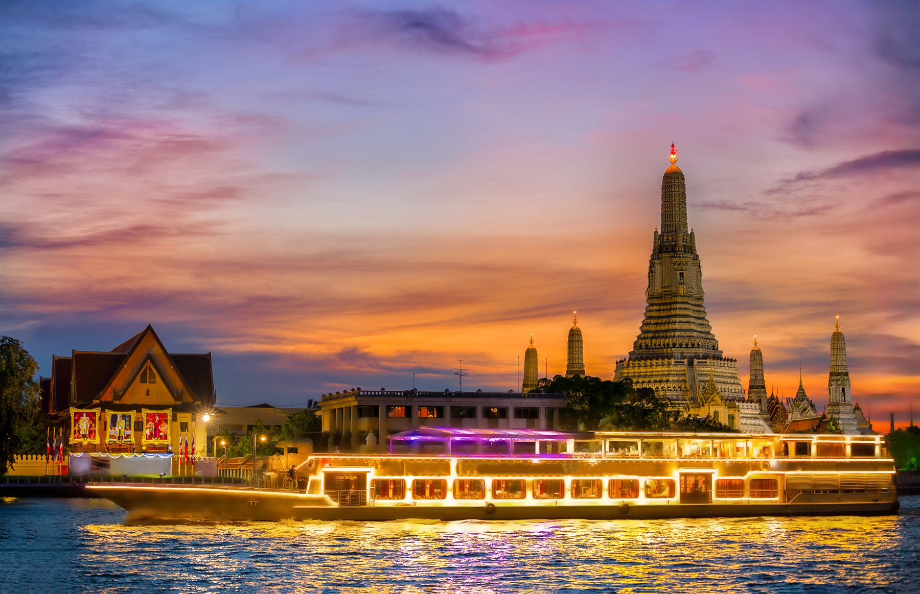 Wat Arun temple and a boat on the Chao Phraya river in Bangkok, Thailand